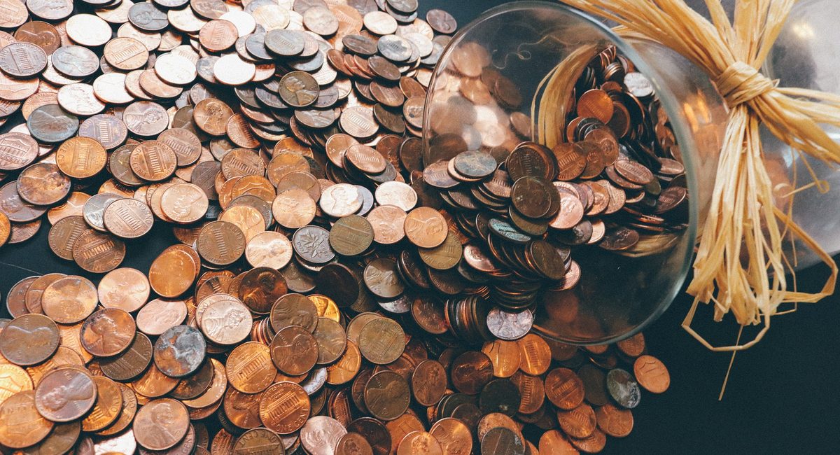 Borrowing vs Saving Money | coins near a money savings jar